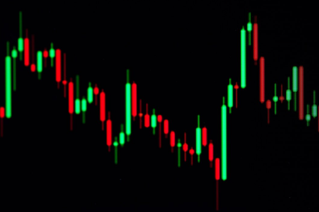 A close-up of a digital stock market chart with red and green bars